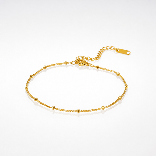 A delicate gold chain anklet with small bead accents and an adjustable lobster clasp, displayed on a clean white background.