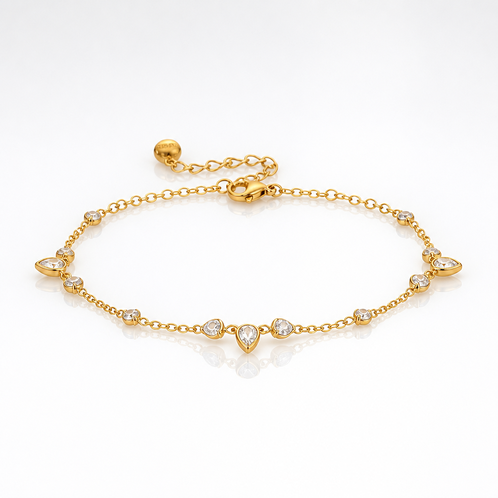 A delicate gold chain anklet bracelet with a central teardrop pendant and small clear gemstone accents, displayed on a clean white background.