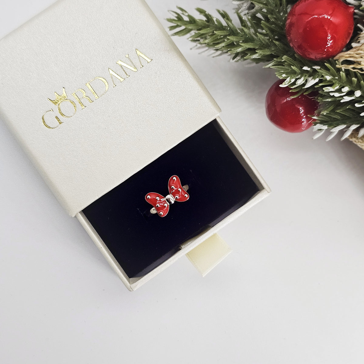 A luxury and cute Sterling silver ring with a red bow with silver dots displayed in a branded Gordana jewelry box. Gordan Jewelry Mauritius.