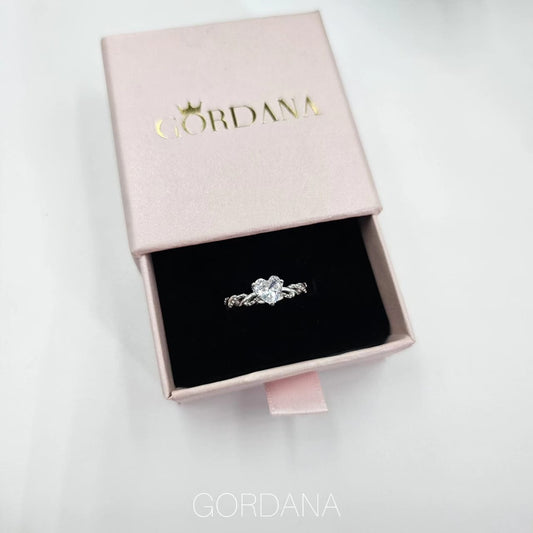 Silver stainless steel promise ring with heart-shaped gemstone in pink velvet-lined pink box.