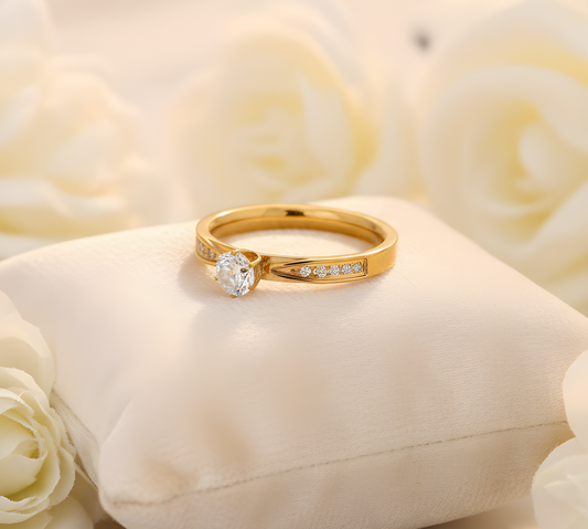 A luxury Gold stainless steel engagement ring with diamonds on a white cushion surrounded by white roses. Gold engagement ring Mauritius and France.