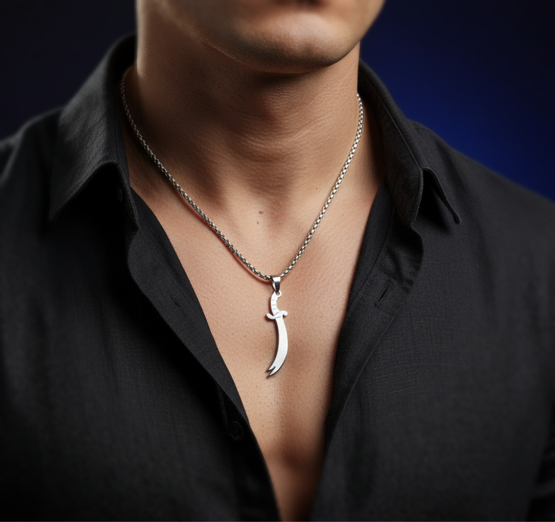 Man wearing a black shirt with a silver necklace featuring a unique pendant against a dark background