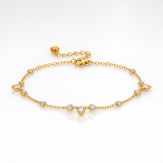A delicate gold chain anklet bracelet with a central teardrop pendant and small clear gemstone accents, displayed on a clean white background.