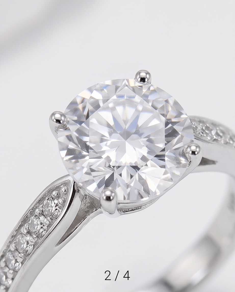A close-up studio shot of a silver-toned solitaire engagement ring with a round brilliant-cut clear center stone and small accent stones along the band, a premium silver engagment ring for woman.