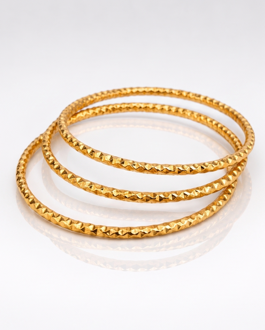 Three gold textured stainless steel bangles for women.