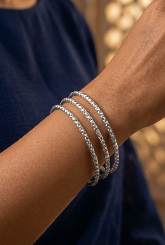 A set of thin textured stainless steel with silver plating bamgles for women.