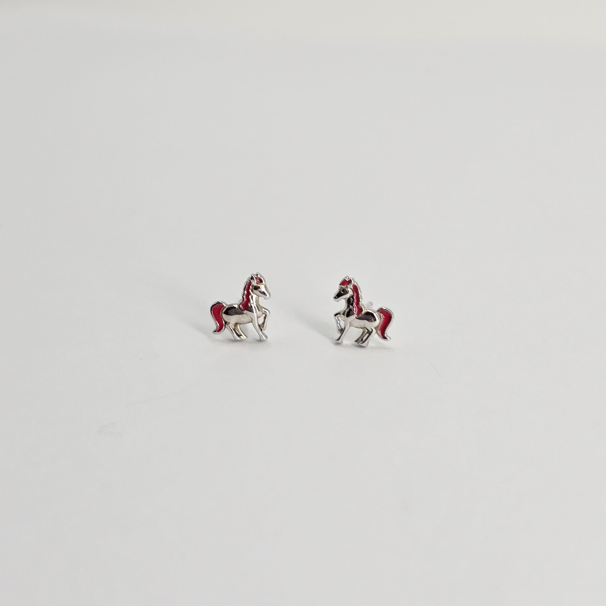 Silver stainless steel horse stud earrings with red accents, stylish unisex fashion jewelry.