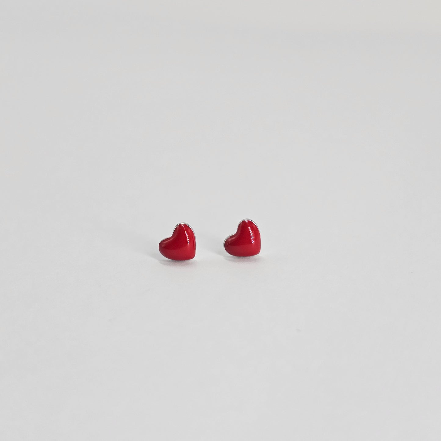 Red heart-shaped silver jewelry studs, elegant fashion jewelry for unisex kids with premium stainless steel finish.