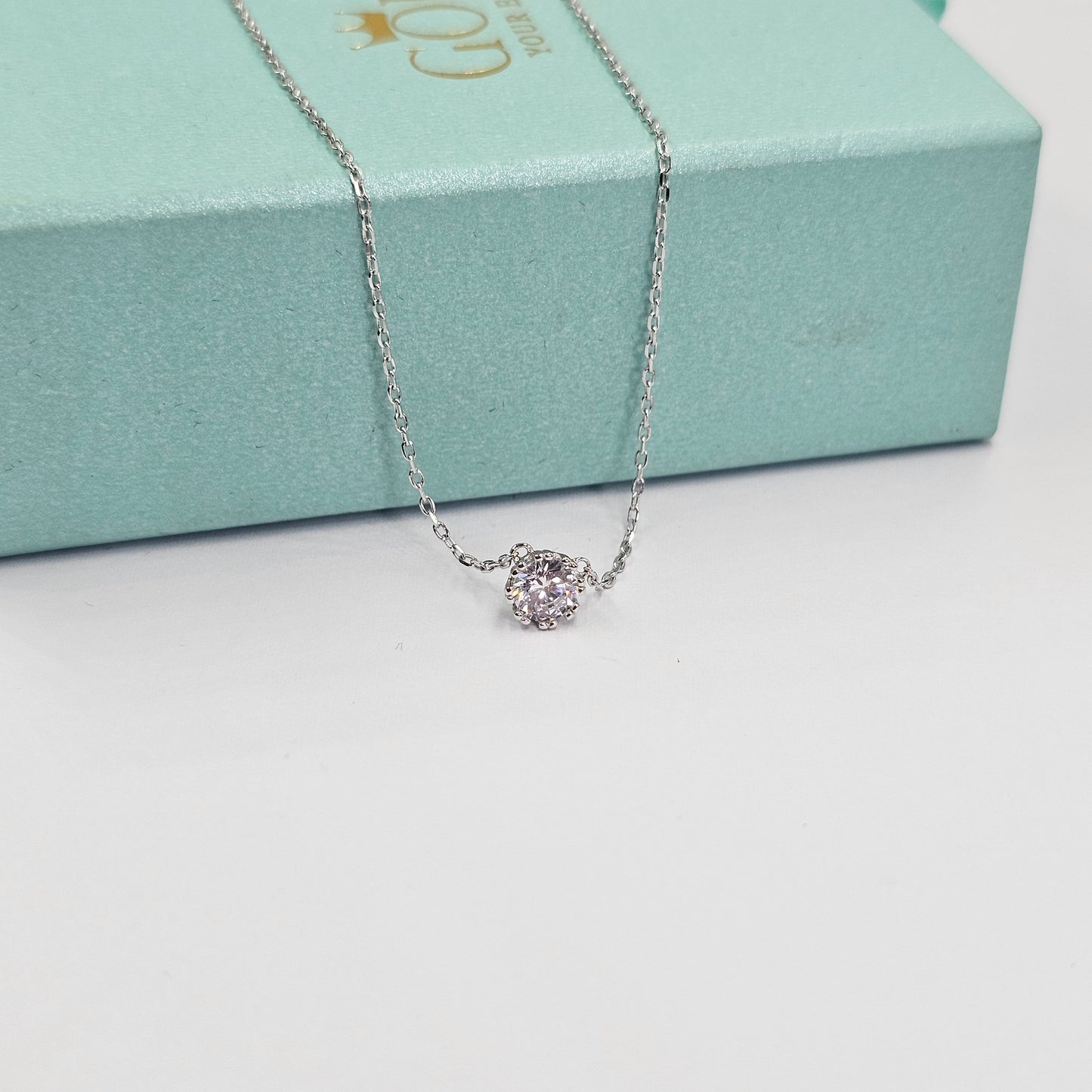 Delicate silver necklace with a sparkling gemstone pendant on a fine chain, stainless steel jewelry, unisex fashion jewelry.