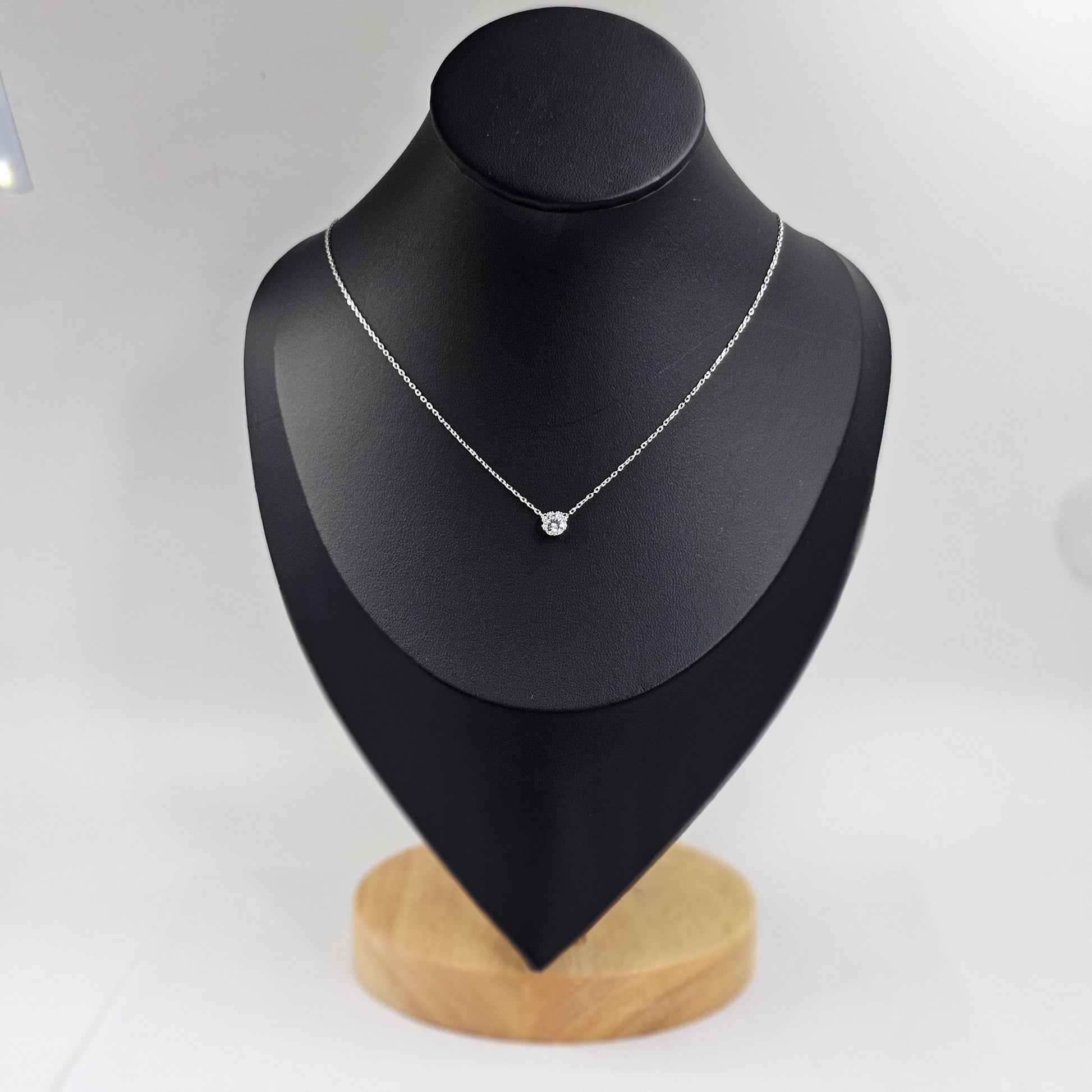 Delicate silver necklace with a single gemstone pendant, stainless steel jewelry, unisex fashion jewelry reflecting.