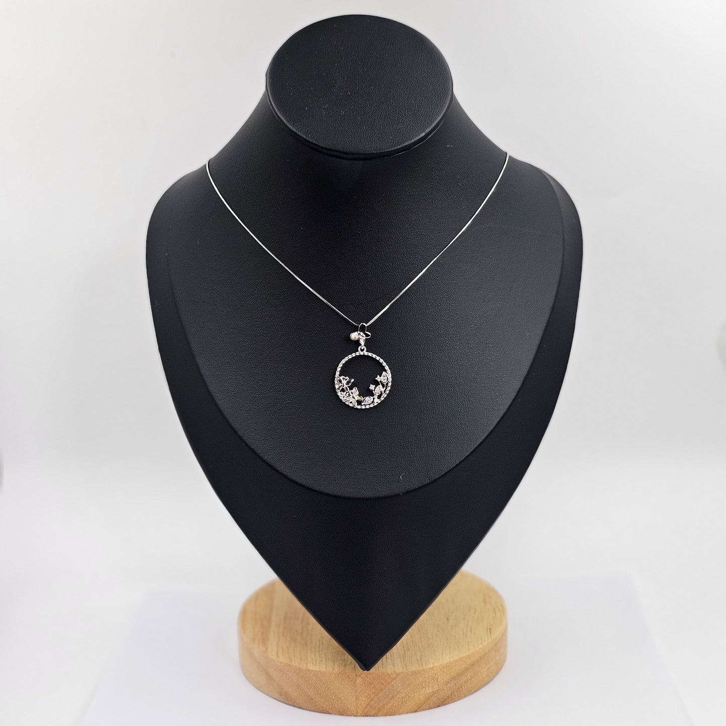Silver stainless steel necklace with circular pendant featuring butterfly and floral gemstone design, unisex fashion jewelry .