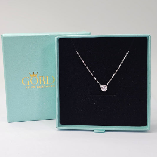 Elegant silver necklace with a delicate gemstone pendant in a black velvet box, showcasing stainless steel jewelry and.