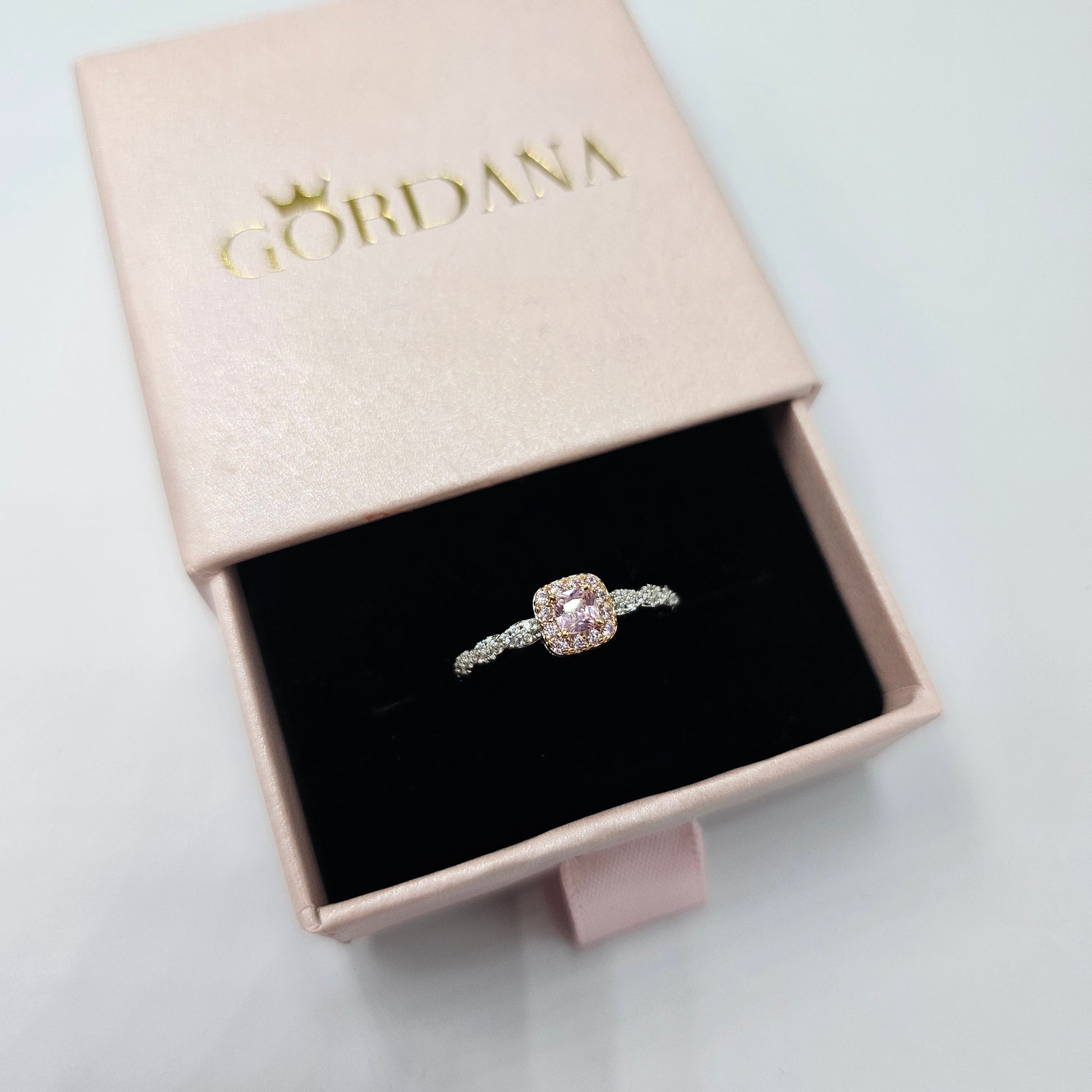 Silver and rose gold stainless steel ring with central pink gemstone, elegant unisex fashion jewelry.