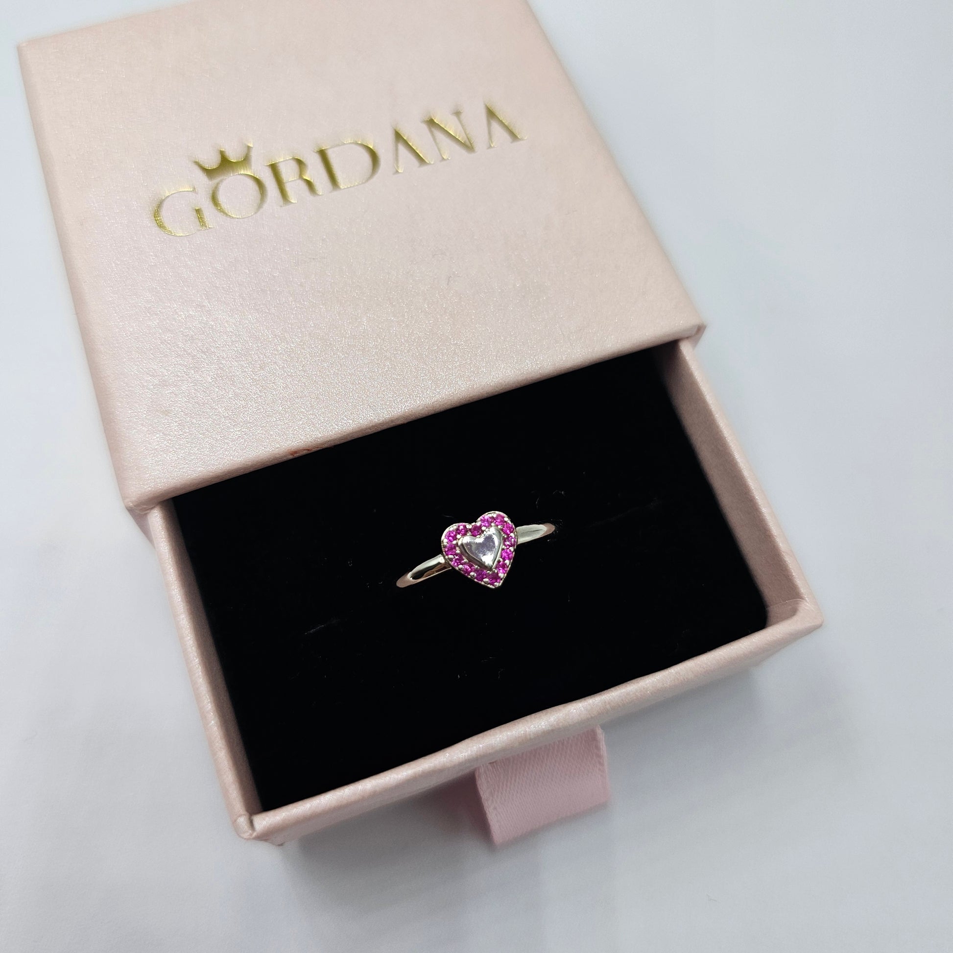 Silver jewelry heart-shaped ring with pink gemstone, stainless steel fashion jewelry, unisex style.