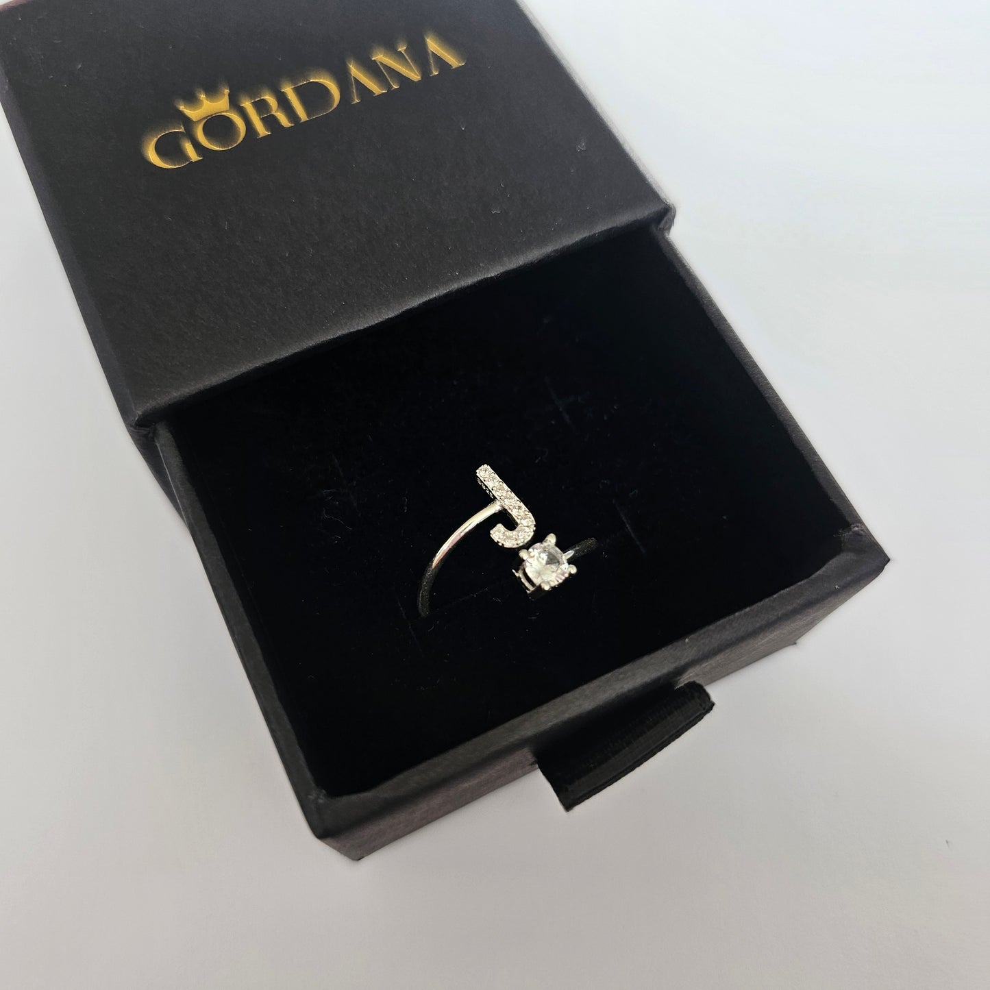 Silver alphabet ring with gemstone detail, stainless steel jewelry in elegant black gift box, unisex fashion jewelry rich in .