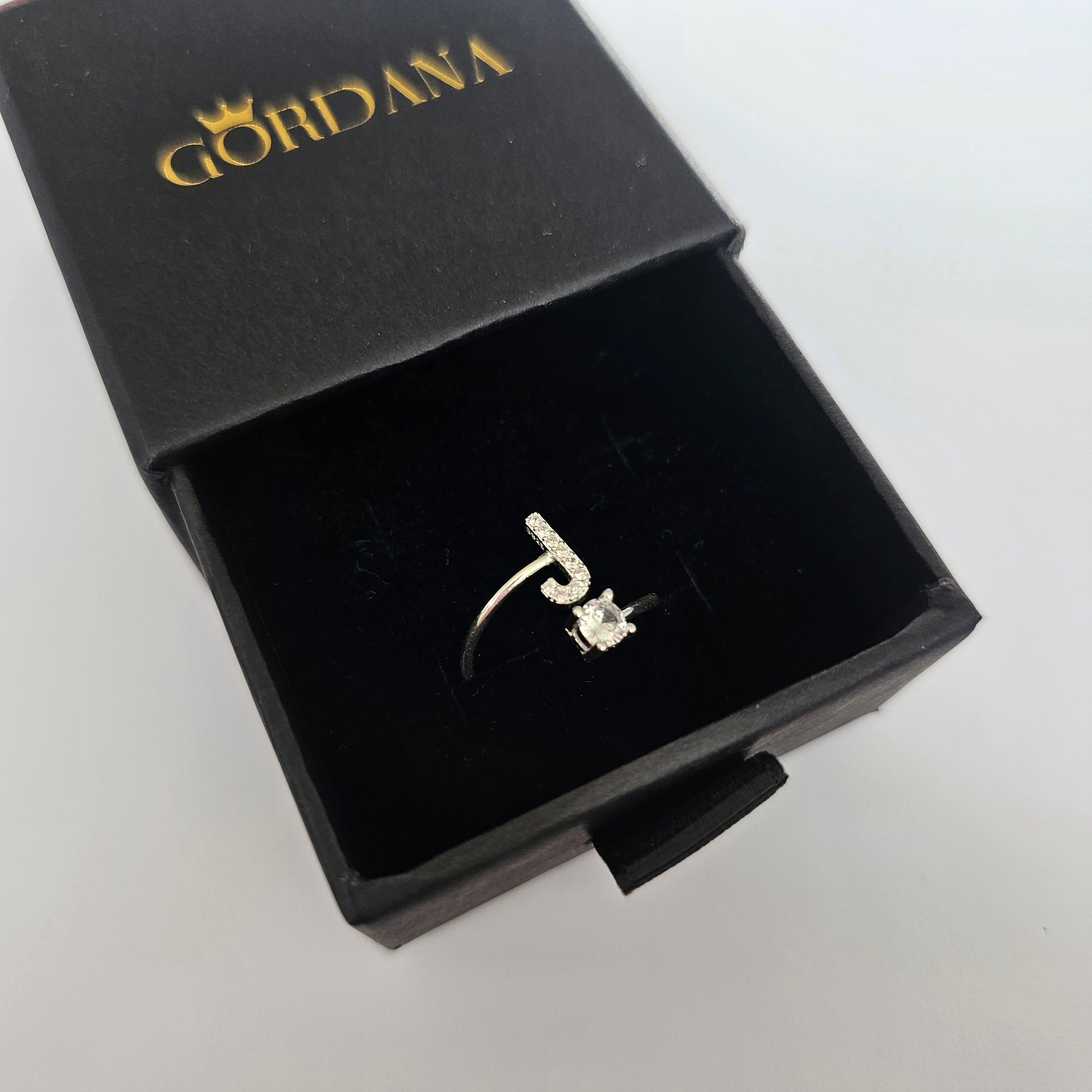Silver alphabet ring with gemstone detail, stainless steel jewelry in elegant black gift box, unisex fashion jewelry rich in .