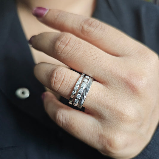 Close-up of a hand wearing three stackable silver rings