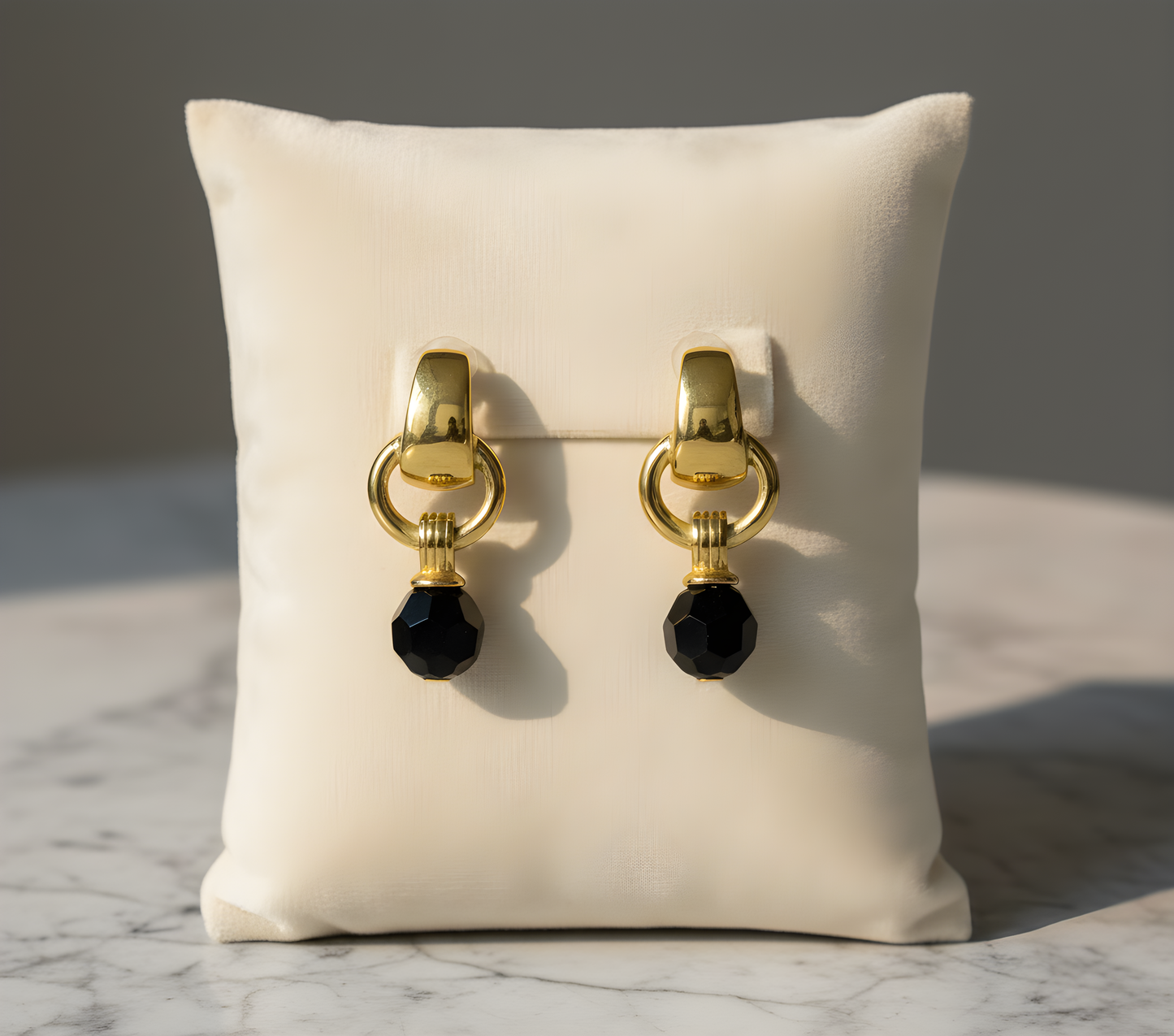Gold earrings with black beads on a white cushion against a marble background - Black beads drop earrings - stainless steel