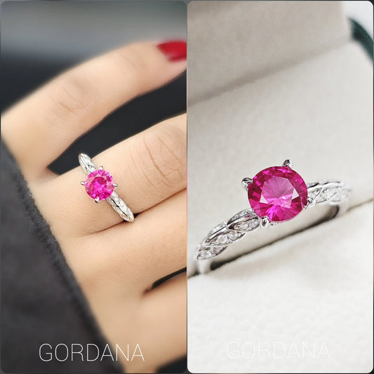 Silver jewelry ring with a vibrant round pink gemstone, stainless steel band with intricate details, unisex fashion jewelry.