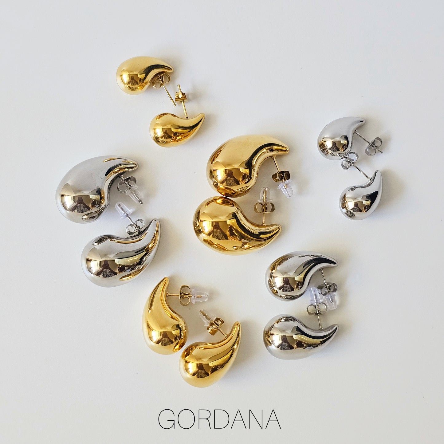 Gold and silver stainless steel Bottega earrings in varied sizes, elegant unisex fashion jewelry with a sleek, curved.