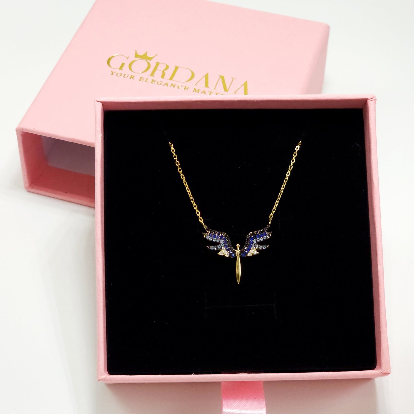 Gold angel wings necklace with blue gemstones on gold chain, stainless steel jewelry, unisex style.