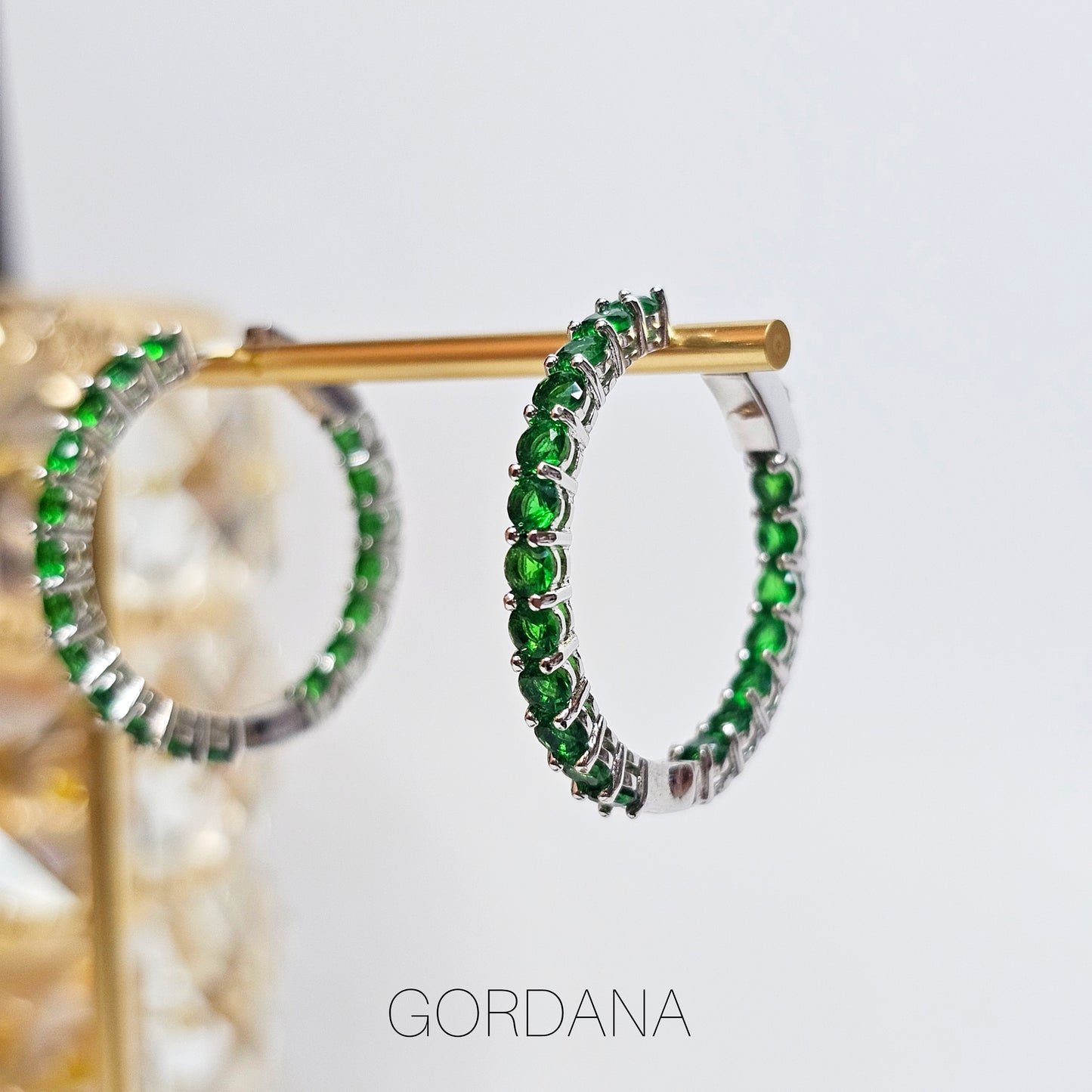Silver stainless steel hoop earrings with vivid green gemstones, elegant unisex fashion jewelry inspired by Mauritius,.