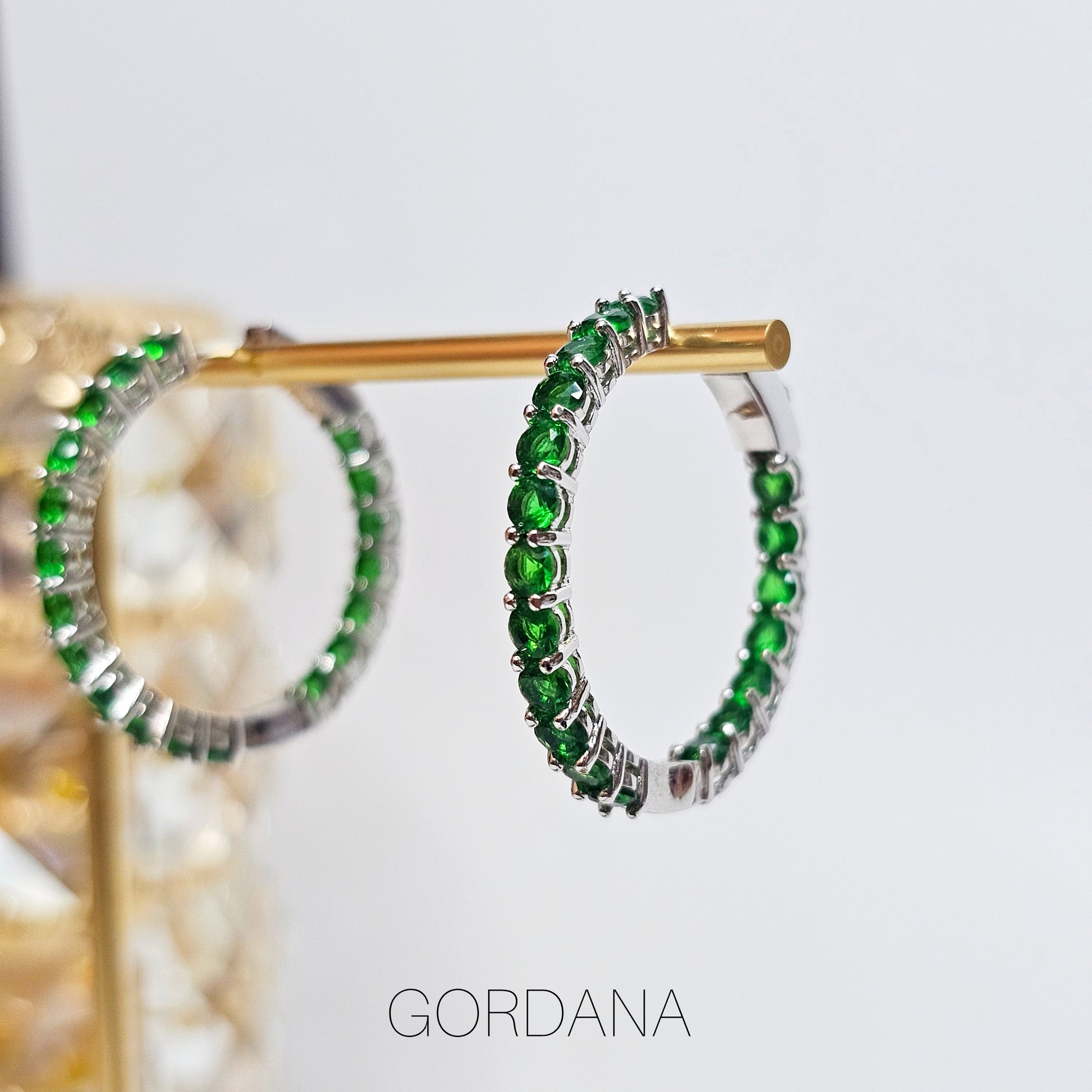 Silver stainless steel hoop earrings with vivid green gemstones, elegant unisex fashion jewelry inspired by Mauritius,.