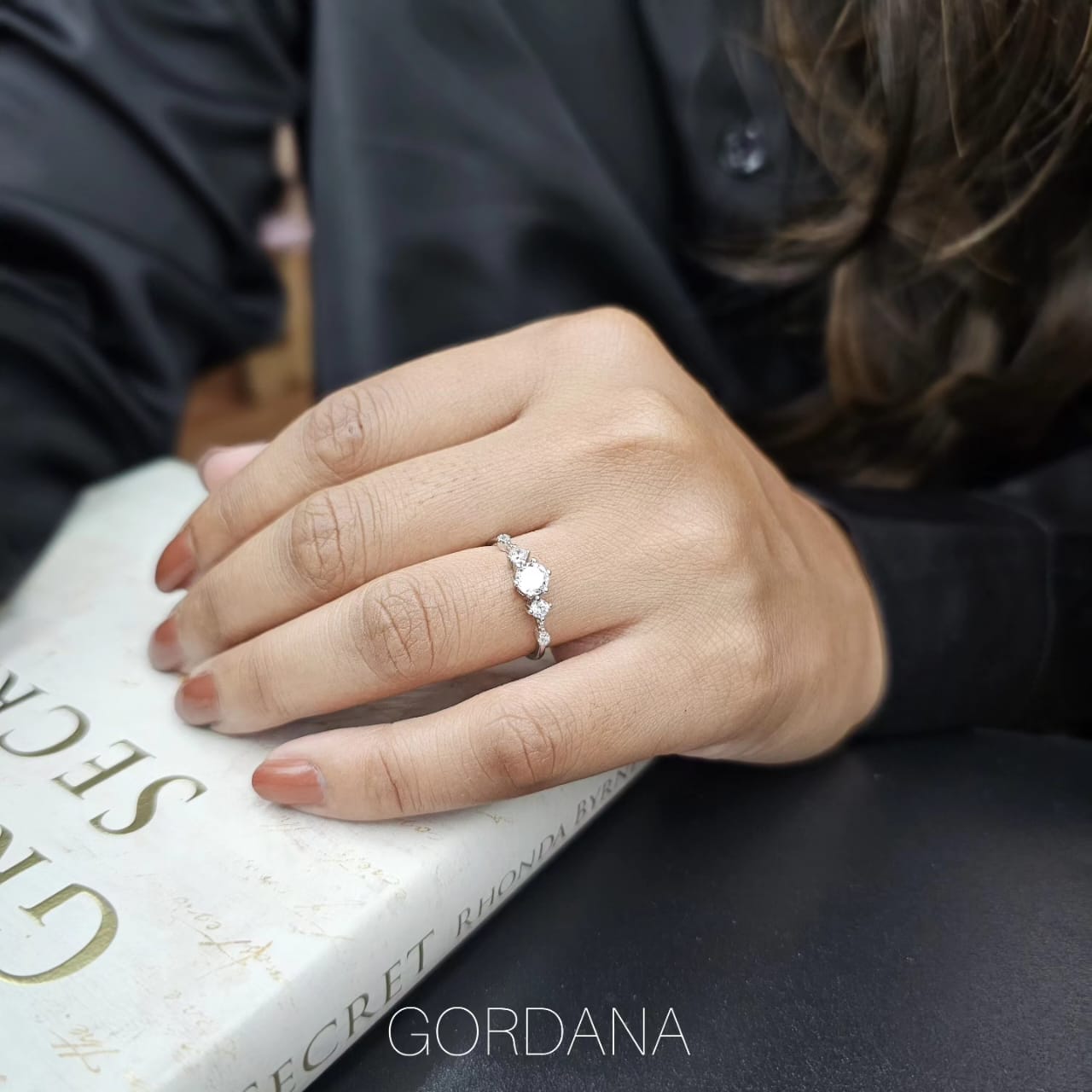 Silver stainless steel promise ring with three small round gemstones, sleek unisex design.