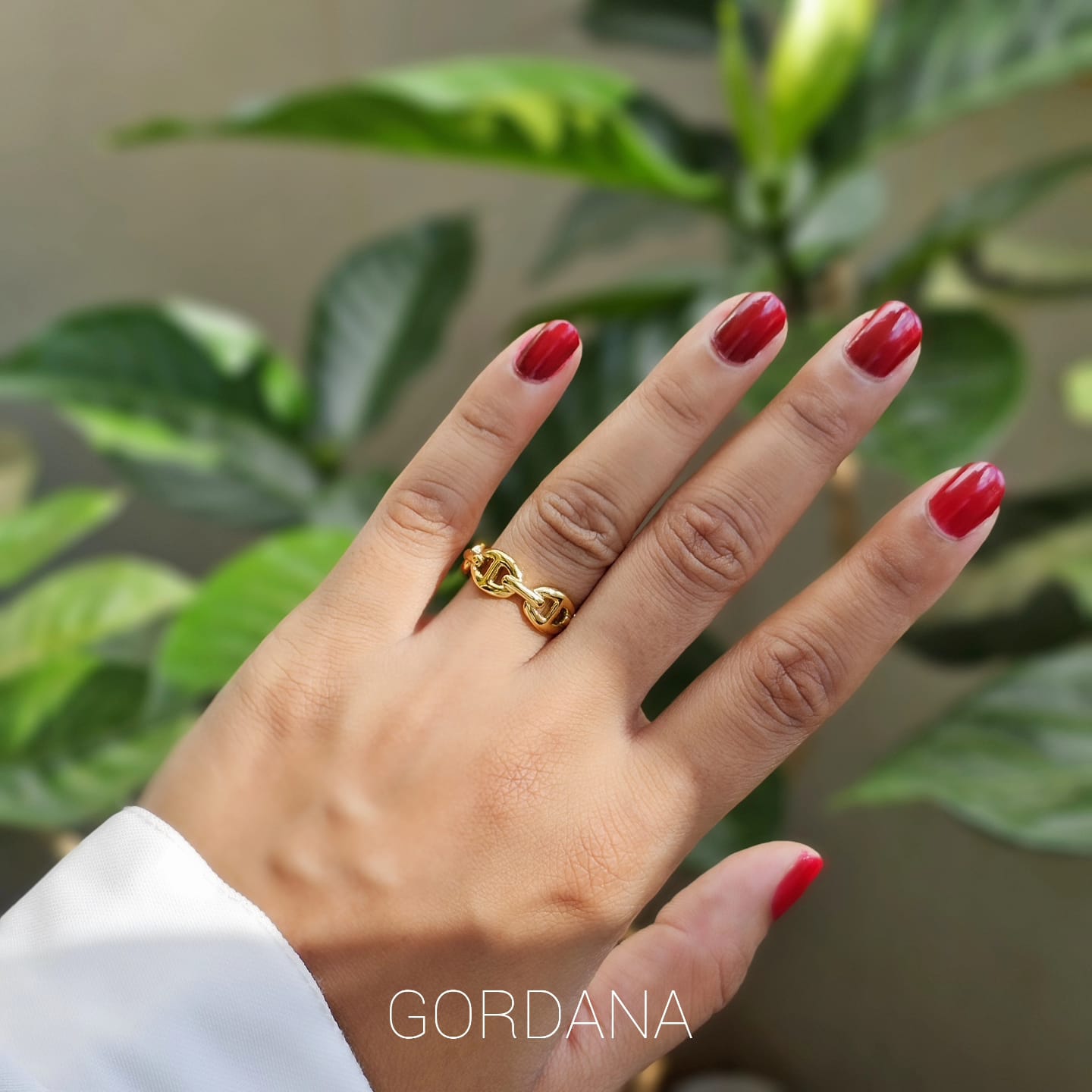 Elegant gold-toned stainless steel jewelry ring with interlocking design, unisex fashion jewelry style.