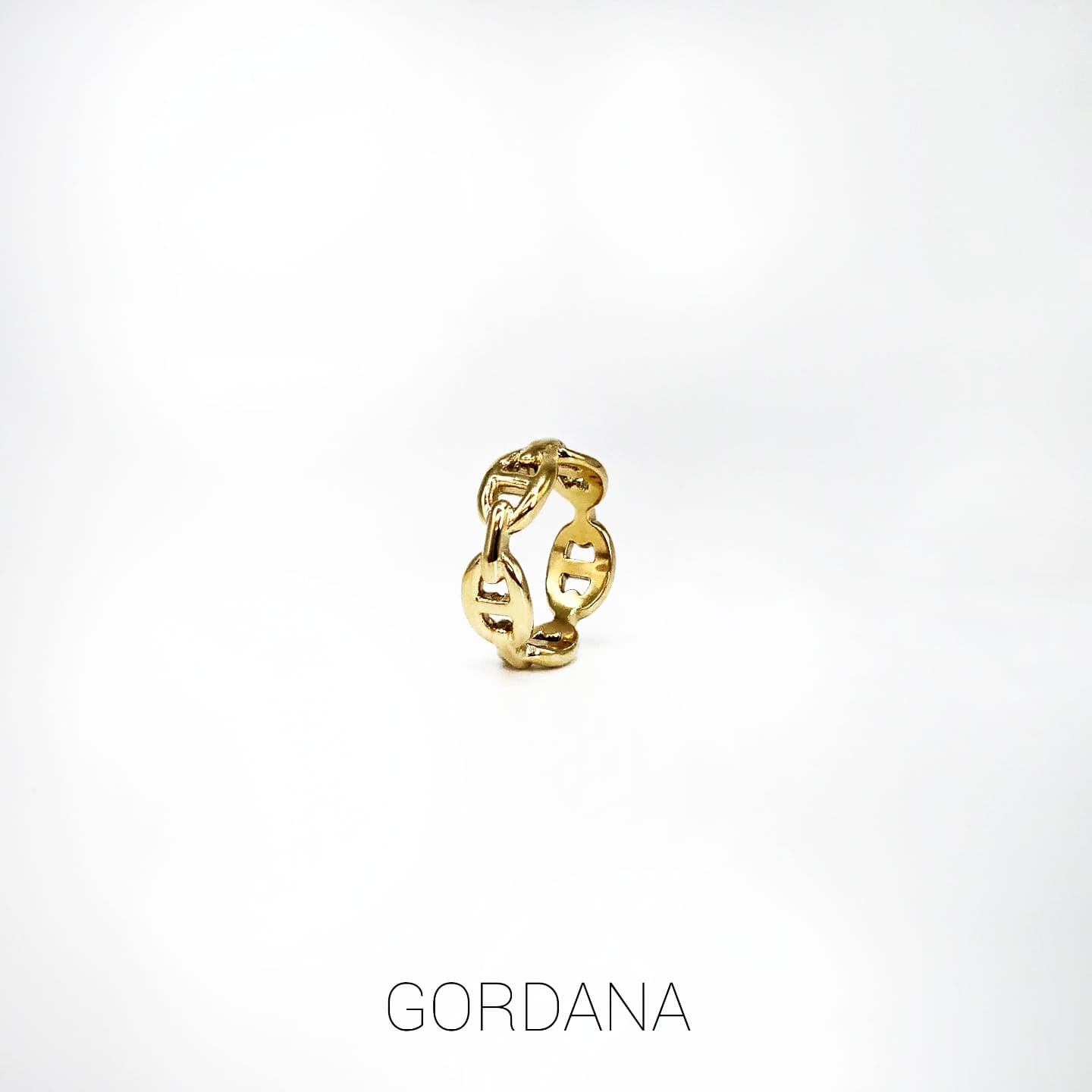 Gold-toned stainless steel ring with an open, chain-link design and polished finish.