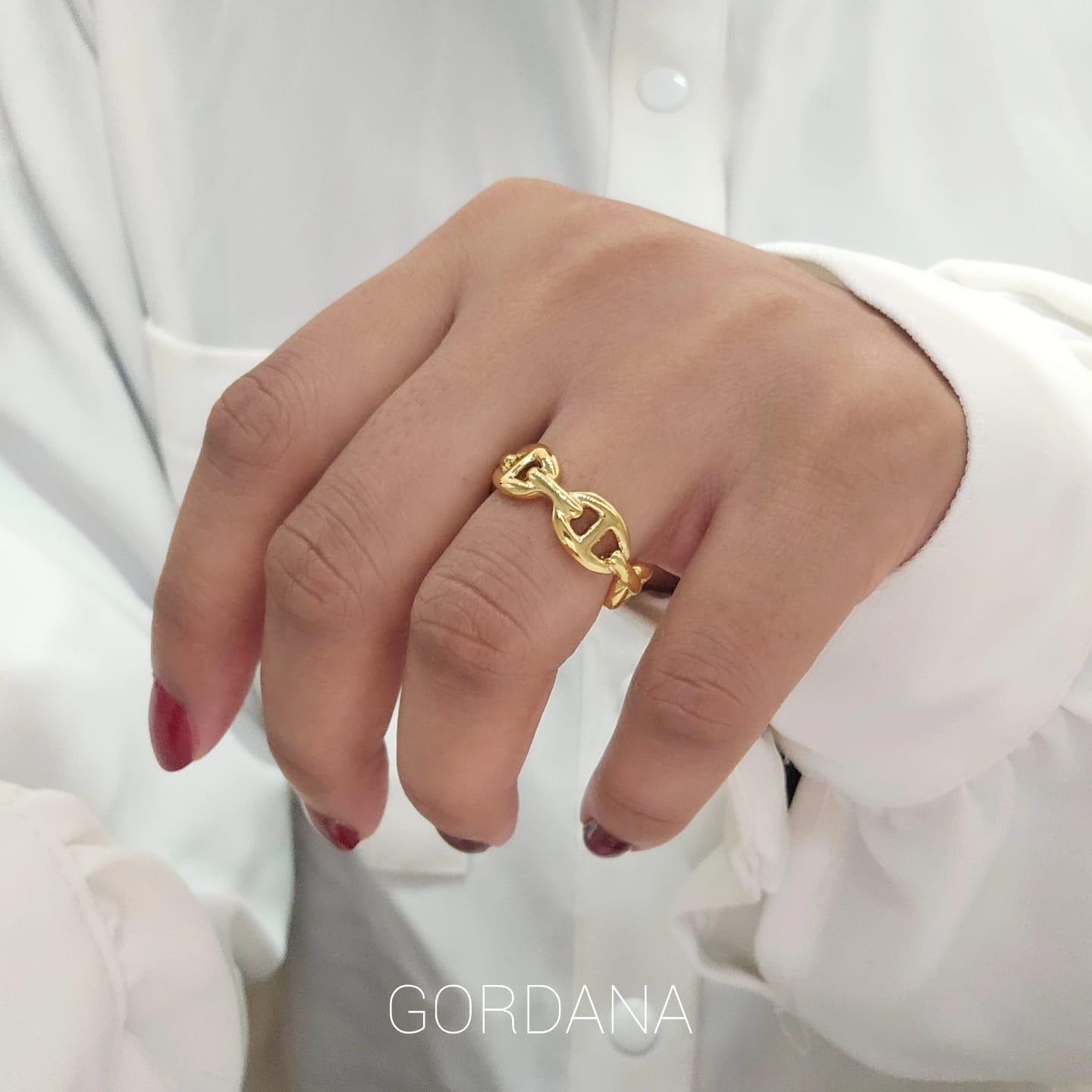 Gold-tone stainless steel ring with intertwined chain design, elegant unisex fashion jewelry.