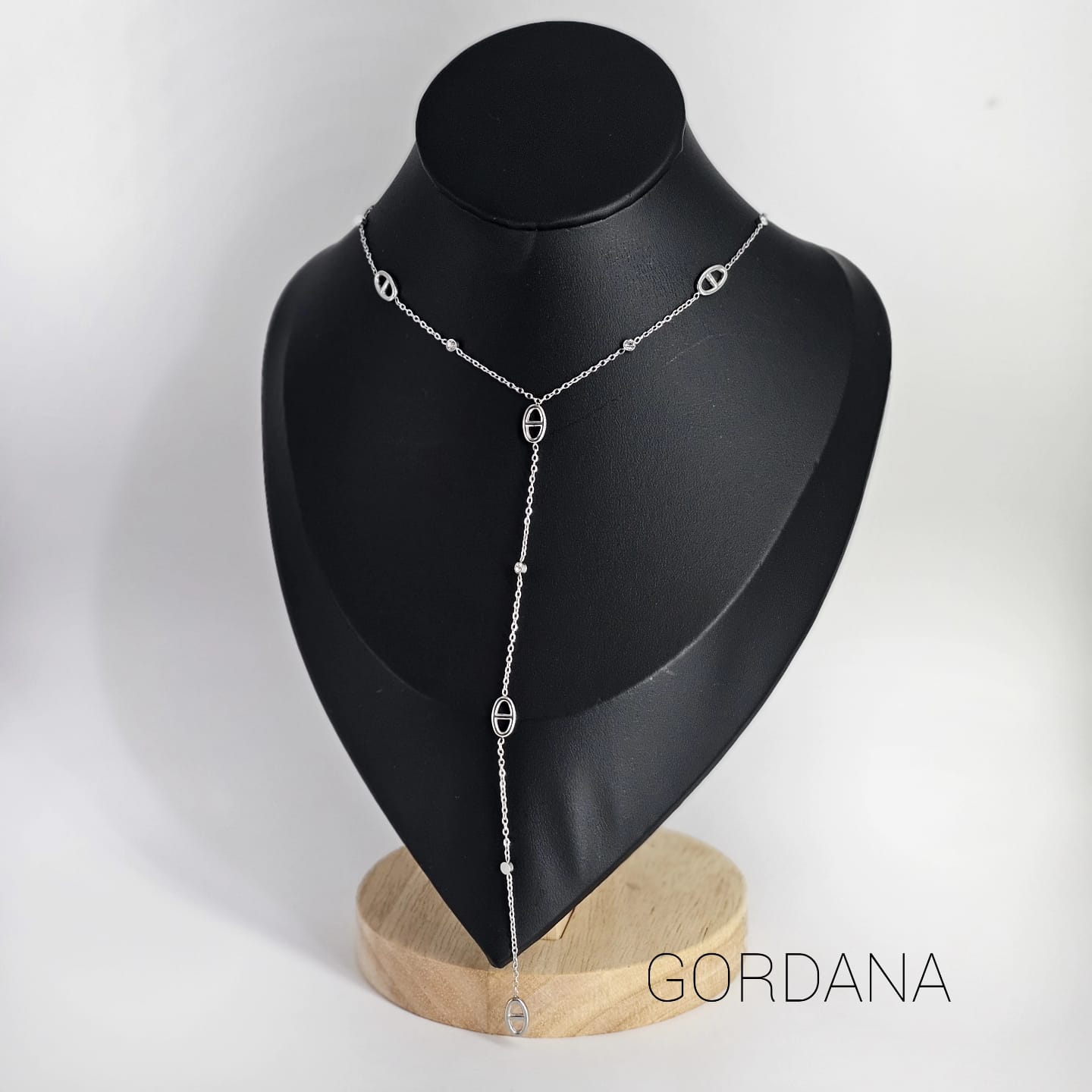 Silver stainless steel Y-shaped necklace with delicate chain and small oval accents on black display bust.