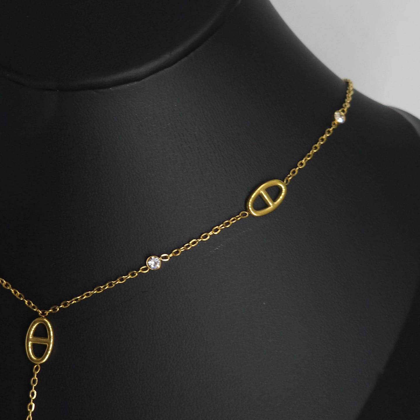 Delicate 18k gold-plated stainless steel necklace with oval links and small clear gemstone accents.