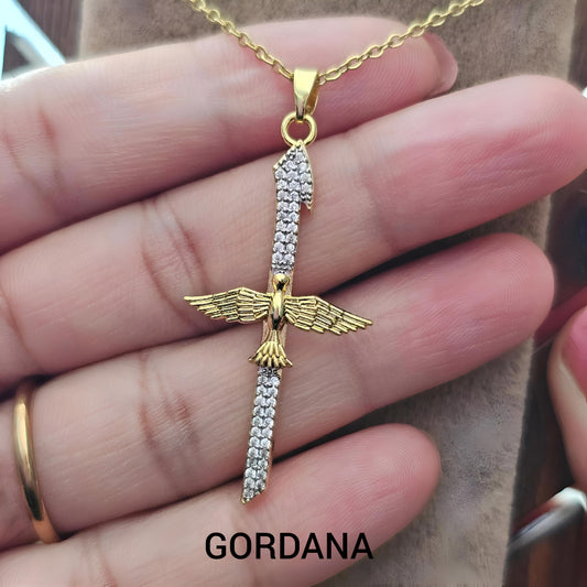 Gold and silver pendant with wings held in a hand, brand 'Gordana' visible - Winged Blade Pendant