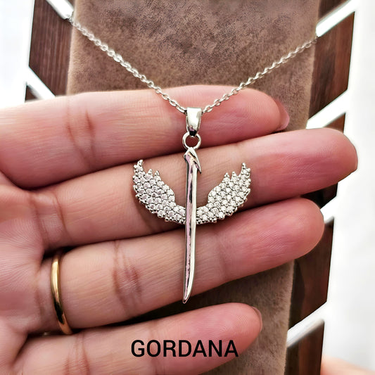 Silver pendant necklace with wings held by a hand, brand 'Gordana' visible Winged Blade Pendant