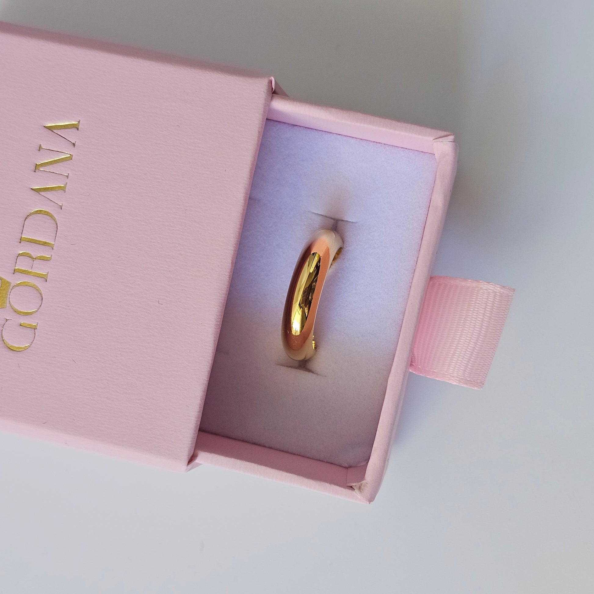 18K gold plated stainless steel ring with sleek curved design, unisex fashion jewelry in pink box.