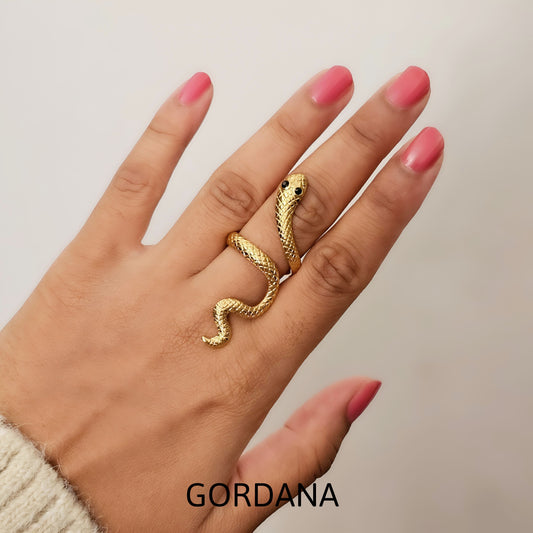 Gold snake-shaped ring on a hand with pink nail polish - stainless steel jewelry shipping worldwide from Mauritius