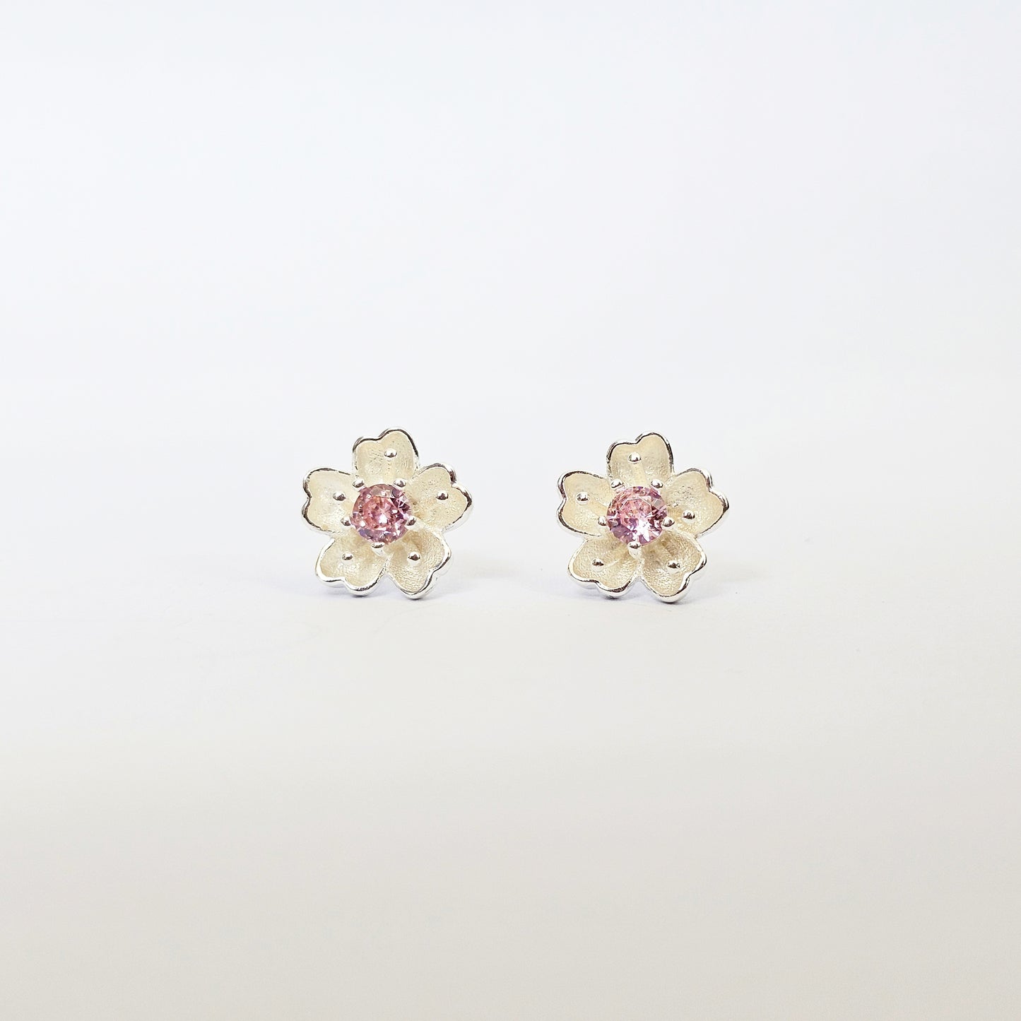 Silver jewelry flower stud earrings with pink gemstone centers, stainless steel fashion jewelry for unisex style.