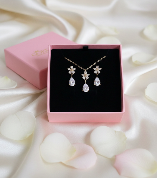 Jewelry set with necklace and earrings in a pink box on a white background